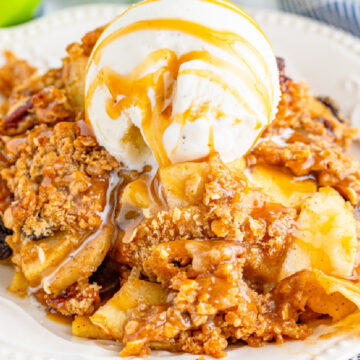 Caramel Apple Pecan Crisp in a white bowl with ice cream.