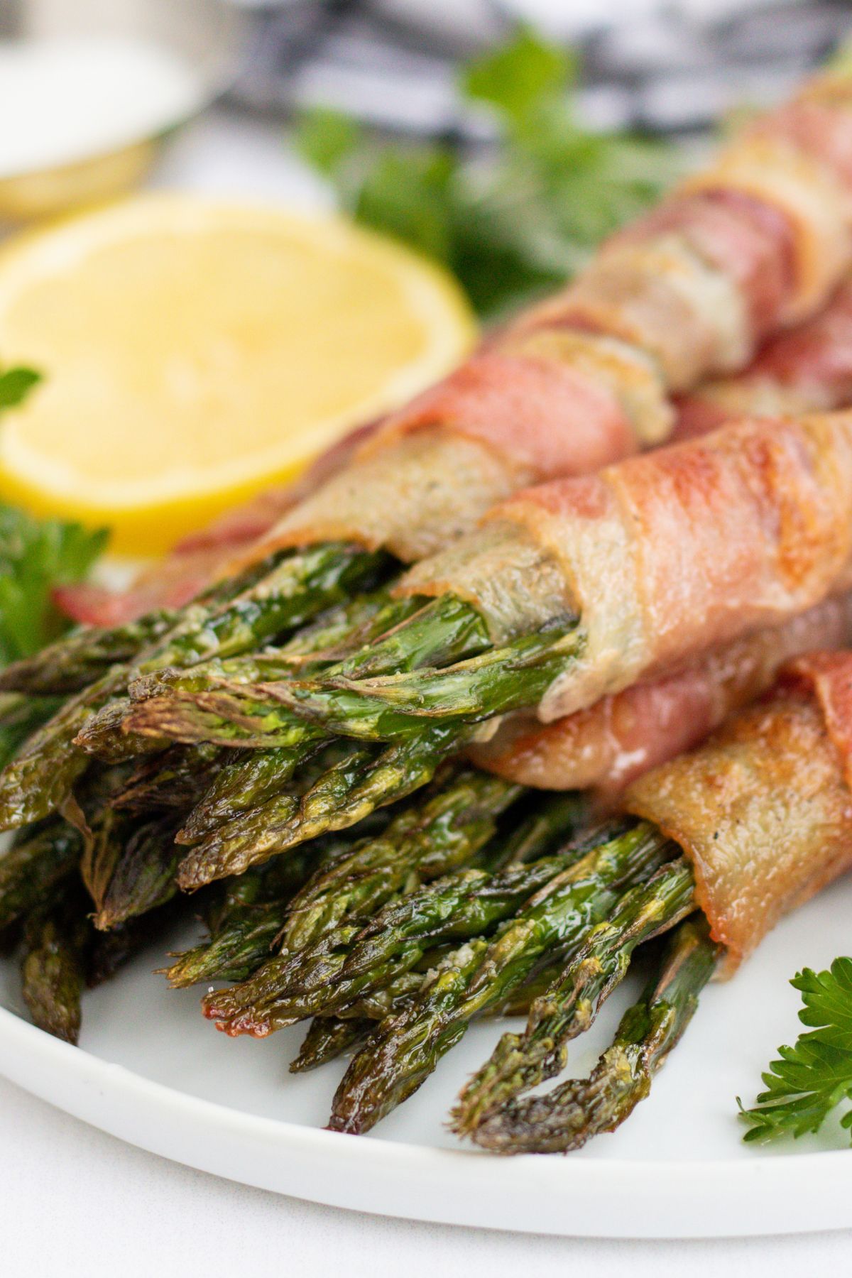 Bacon-wrapped asparagus stacked on a plate.