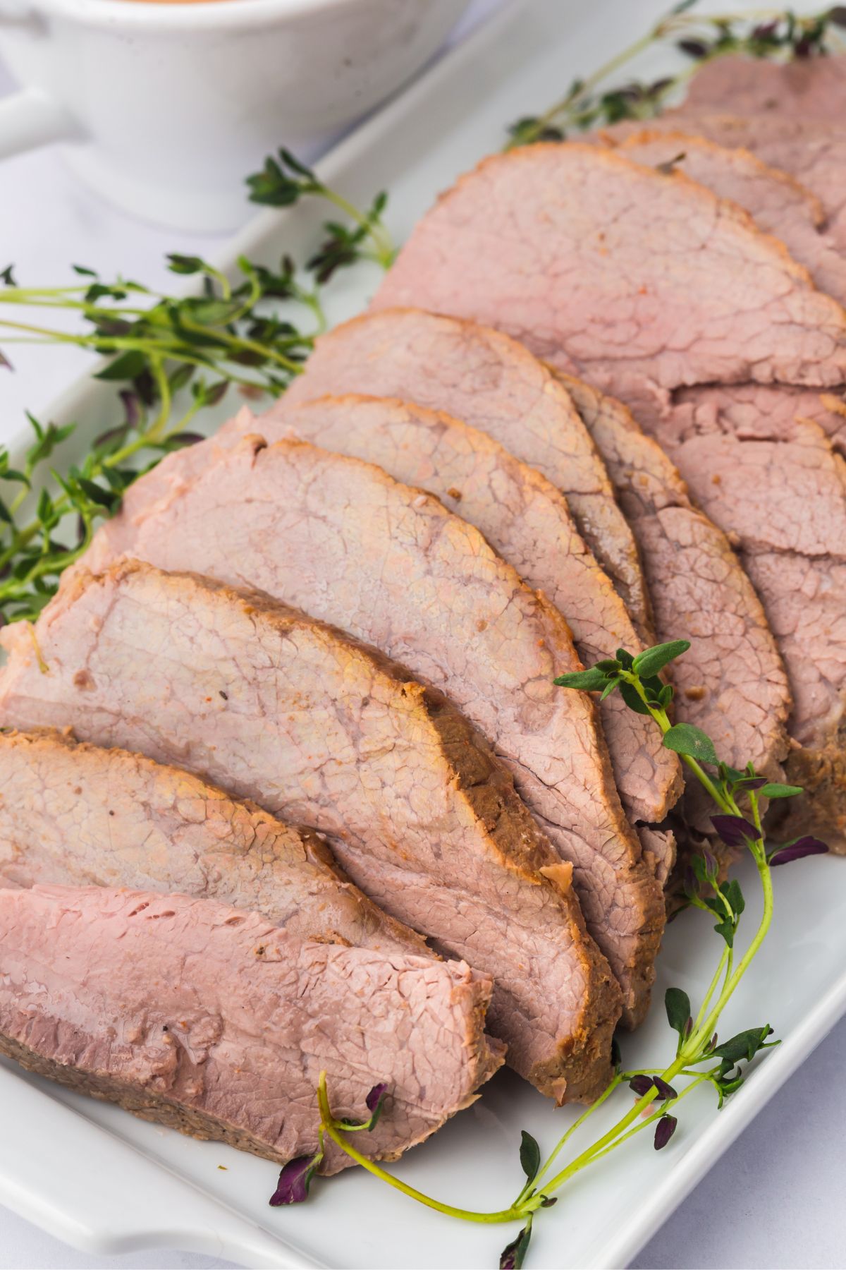 Slices of crock pot eye of round roast on a plate.