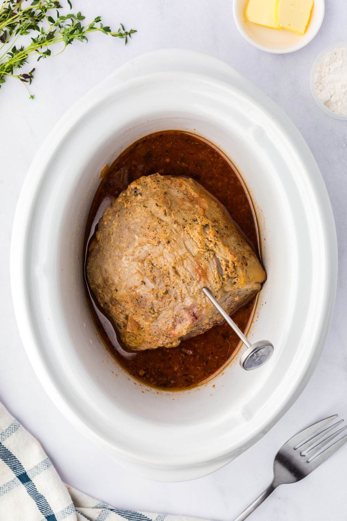 Roast cooking in the slow cooker and checking the internal temperature.