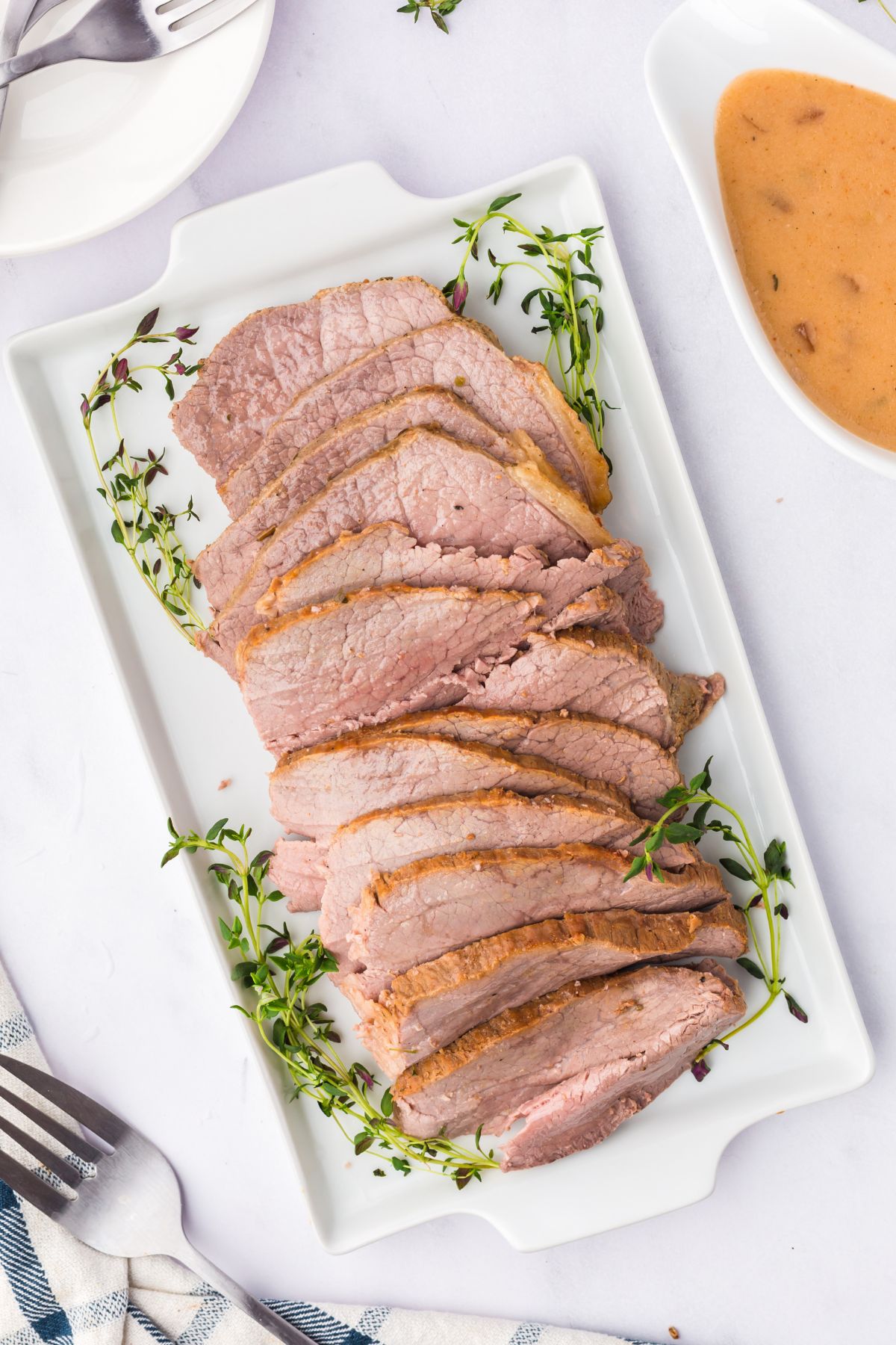 The eye of round roast sliced on a serving platter.