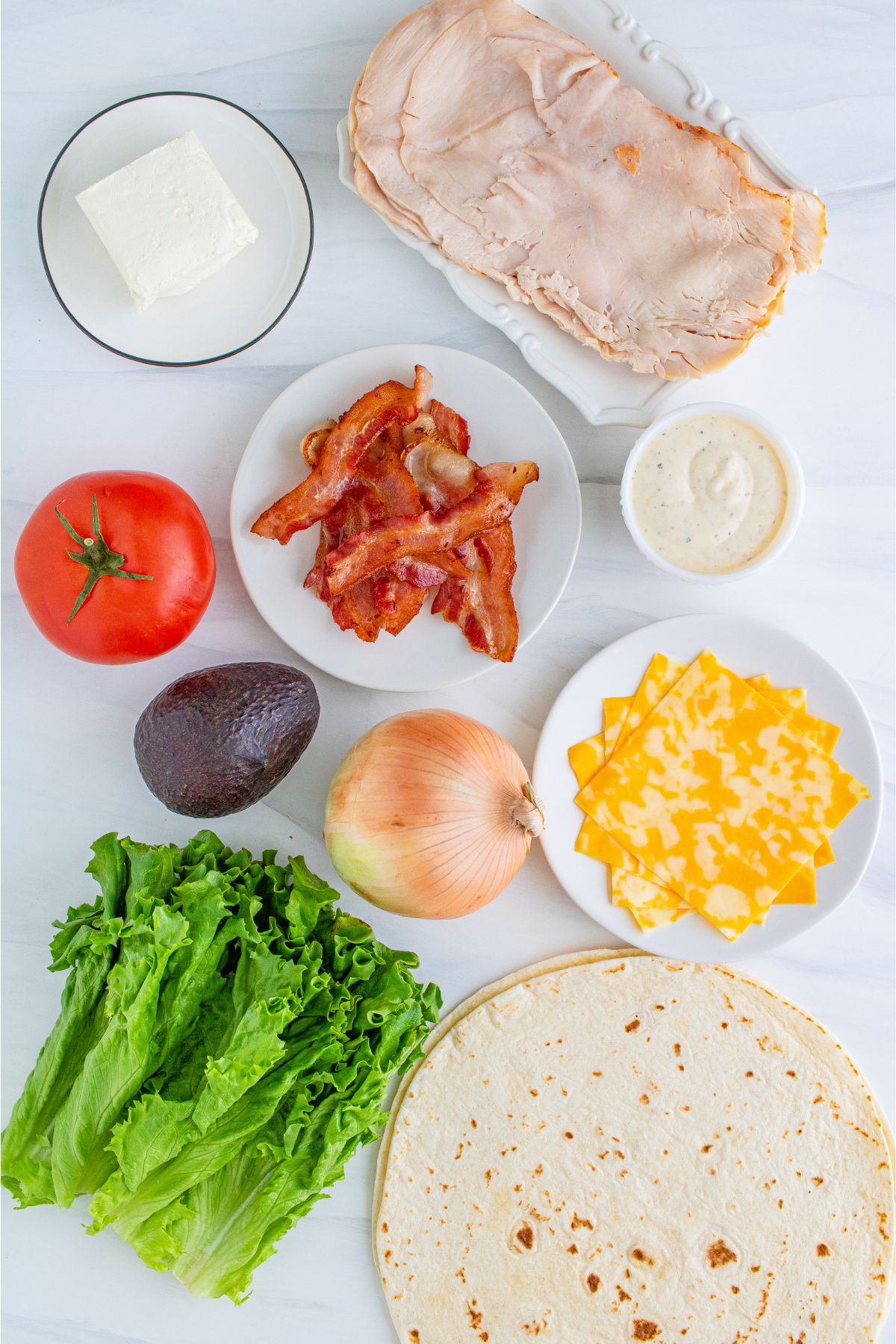 Ingredients for turkey club wrap on a table.