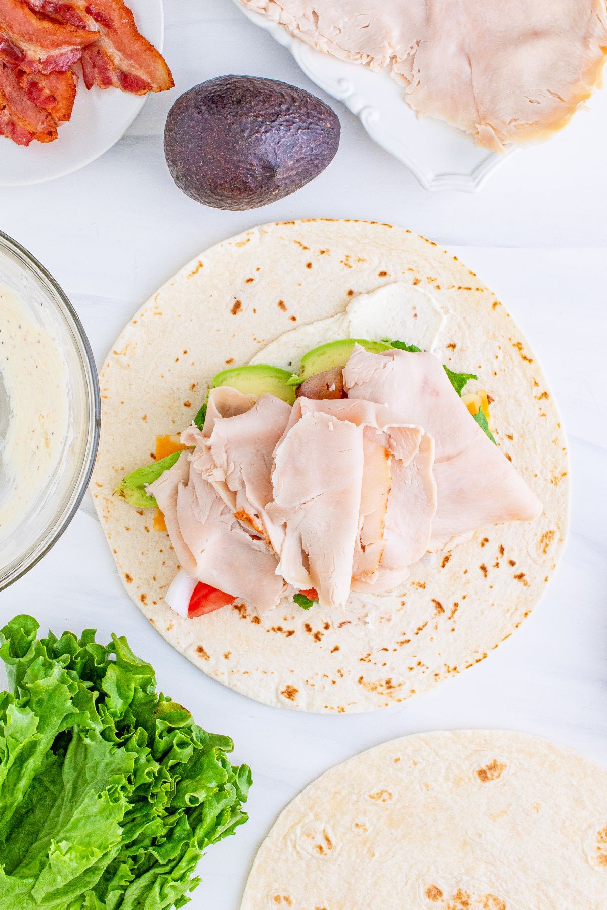 Slices of ham and turkey added to the top of the veggies.