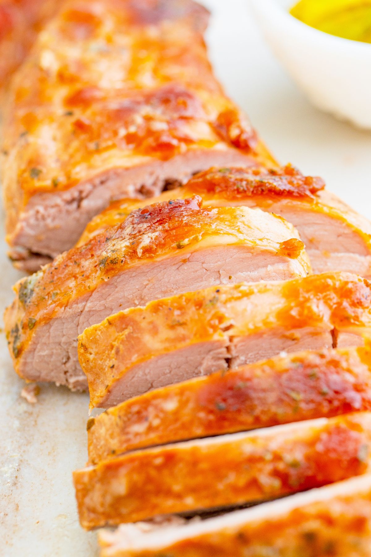 Cooked slow cooker Mississippi pork tenderloin in slices on a table.