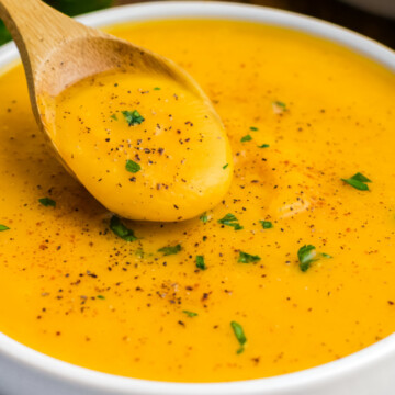 A bowl of soup with a spoonful.