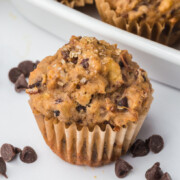 A Banana Lentil Muffin on a table with some chocolate chips.