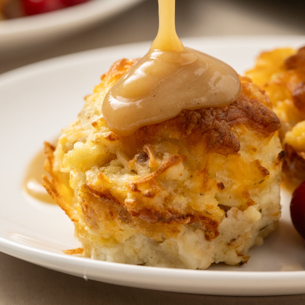Close up of Leftover Turkey and Stuffing Muffins with gravy being poured over top 