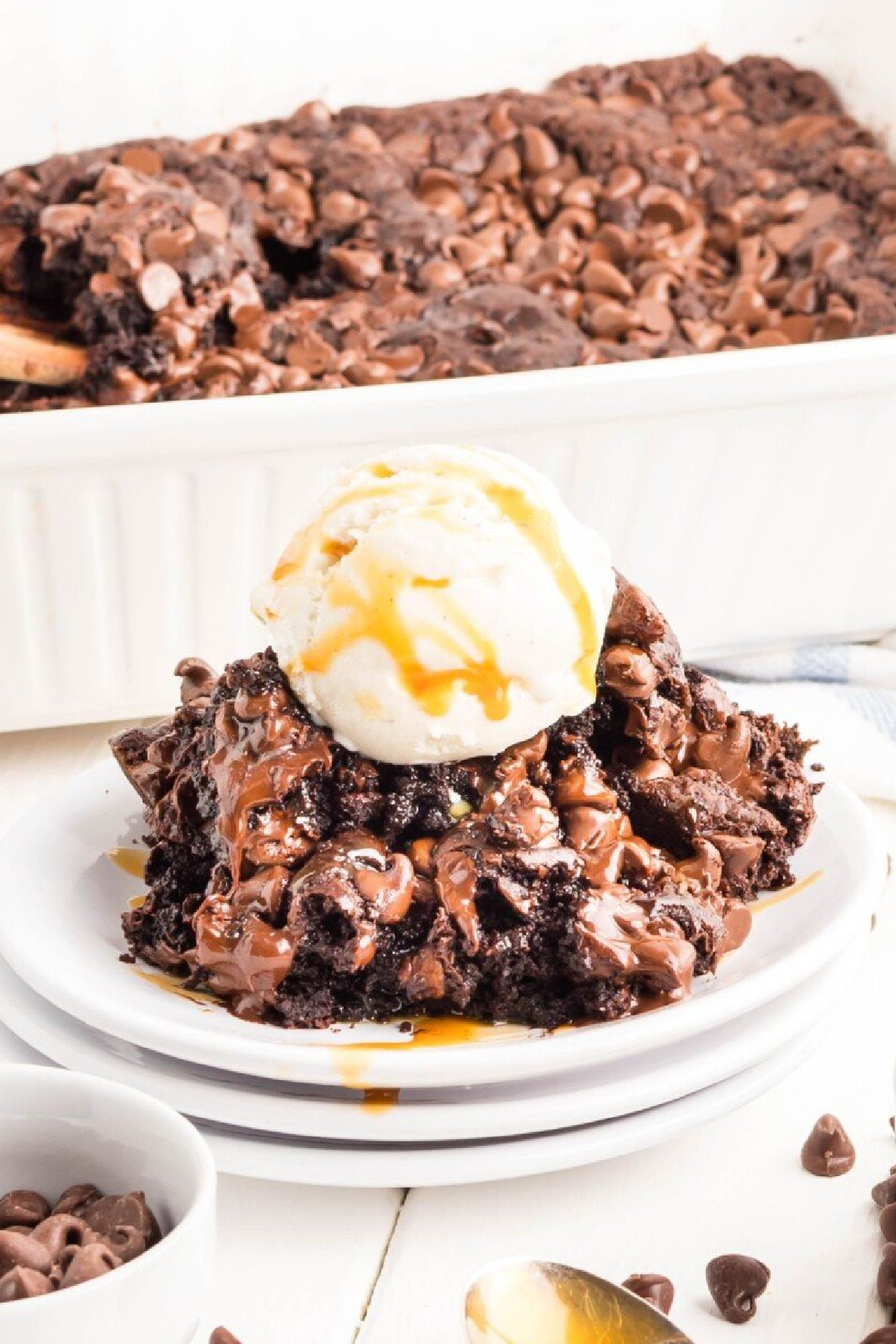 A plate full of pudding cake with a scoop of vanilla ice cream on top.