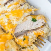 Slices of creamy ranch chicken being stabbed with a fork.