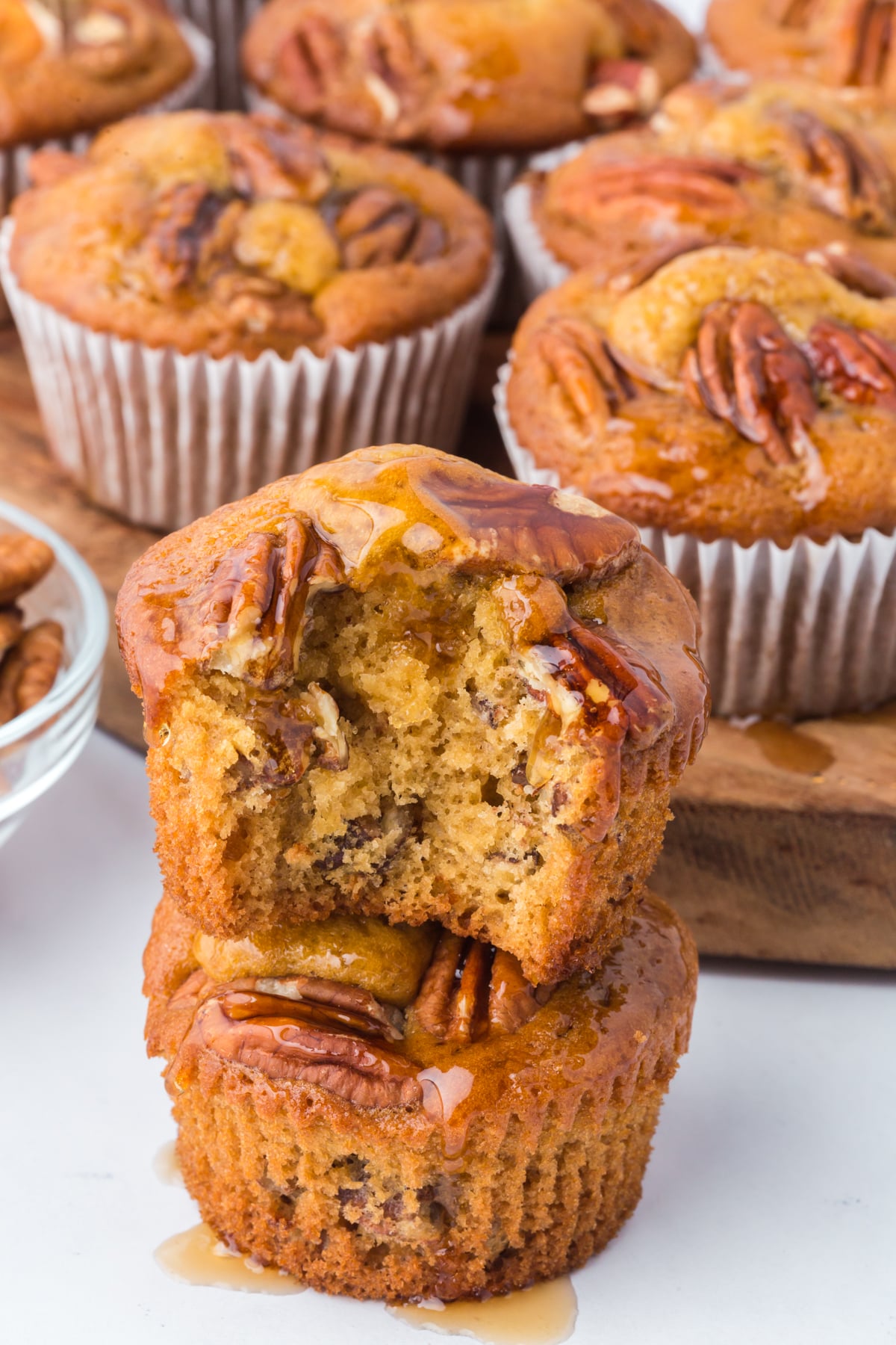 A muffin missing a bite on top of another whole muffin.