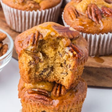A pecan muffin missing a bite on top of another whole muffin.