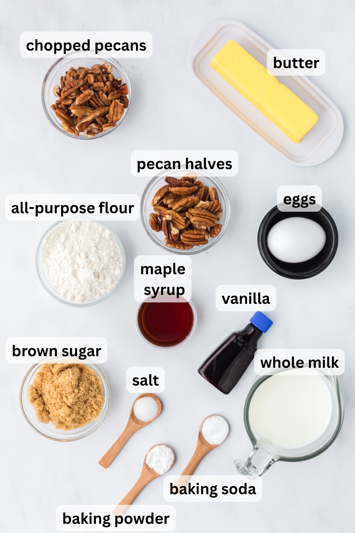 All of the ingredients needed to make pecan muffins in bowls on a table.