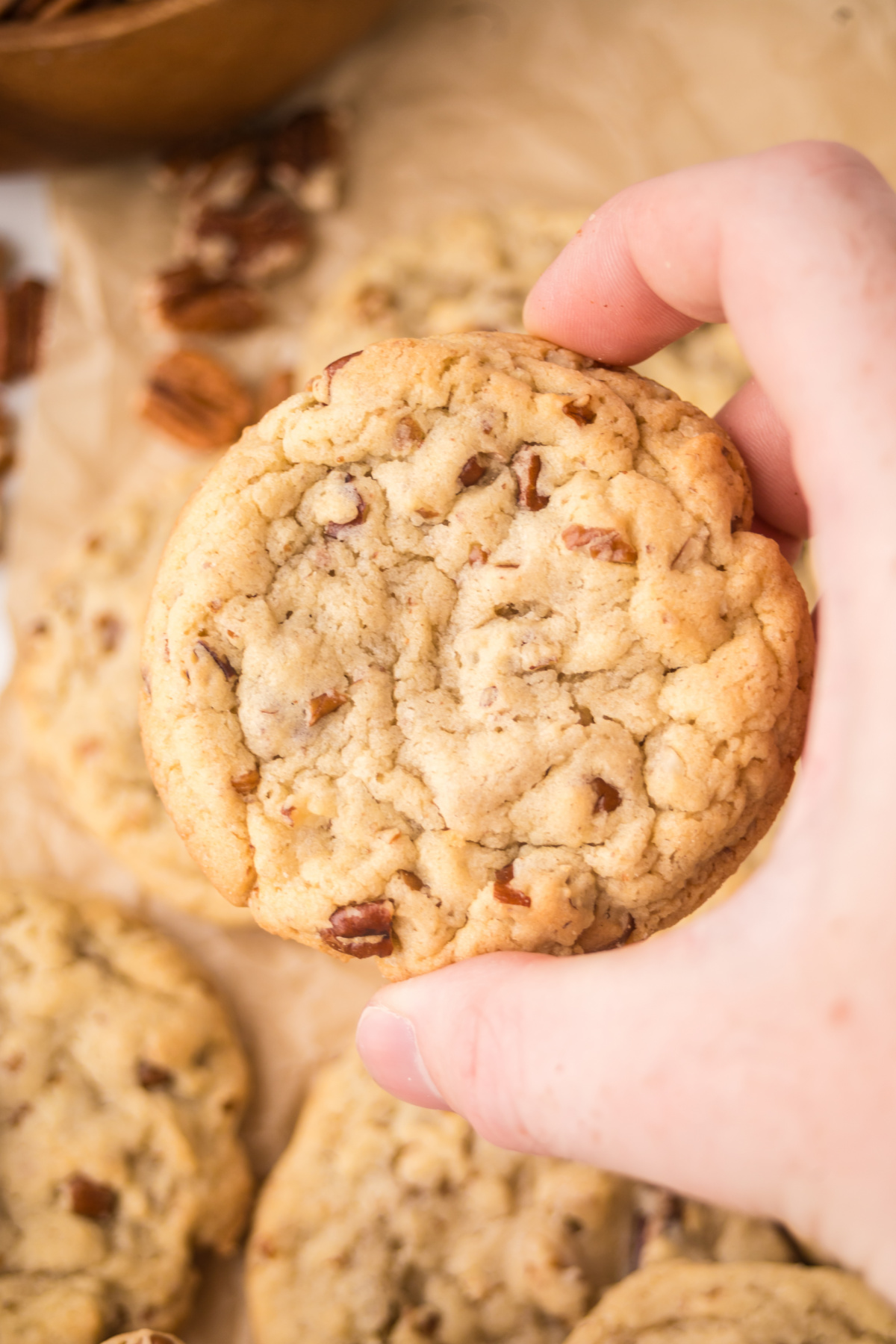 A maple cookie being held up in the air.