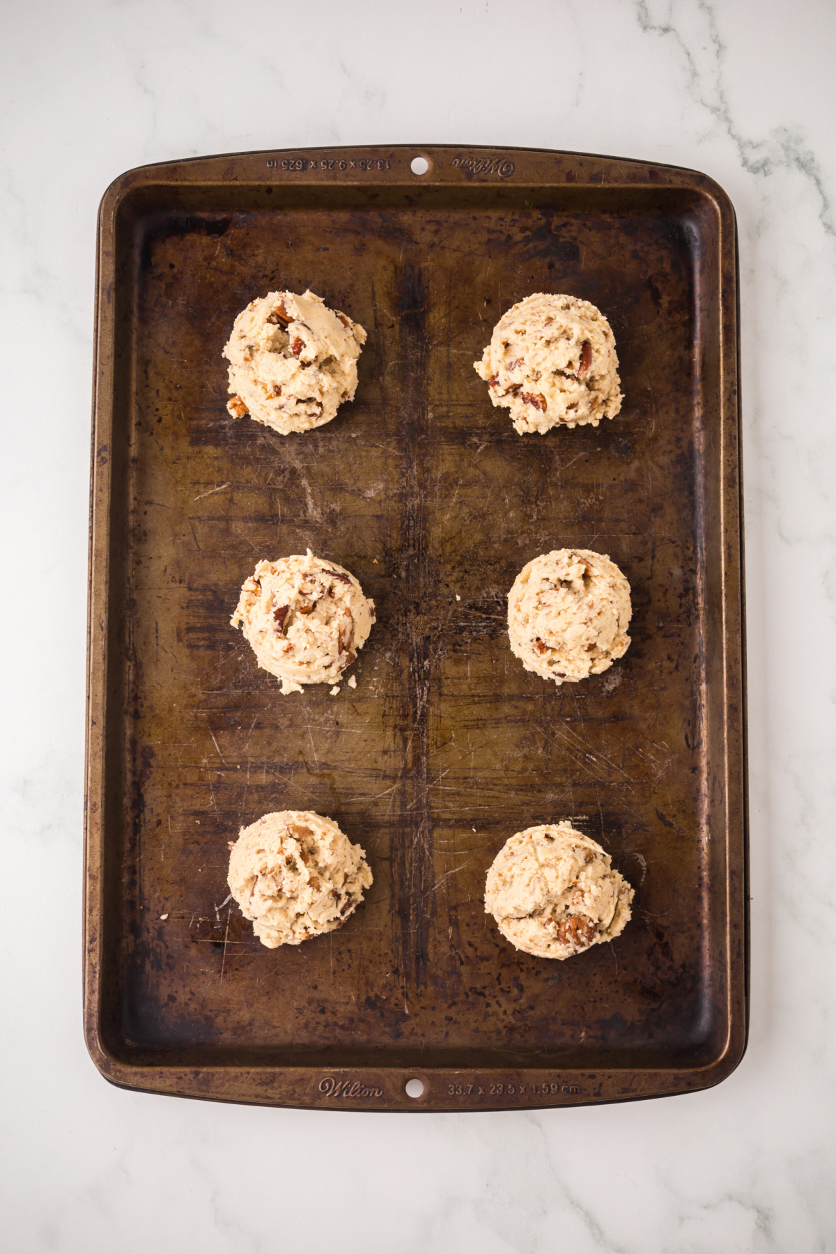 Cookie dough balled dropped onto the baking sheet.