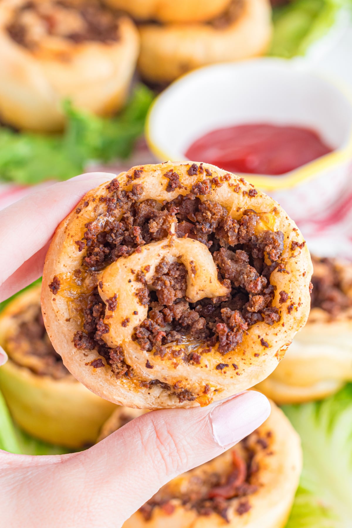A hand holding up a hamburger pinwheel.
