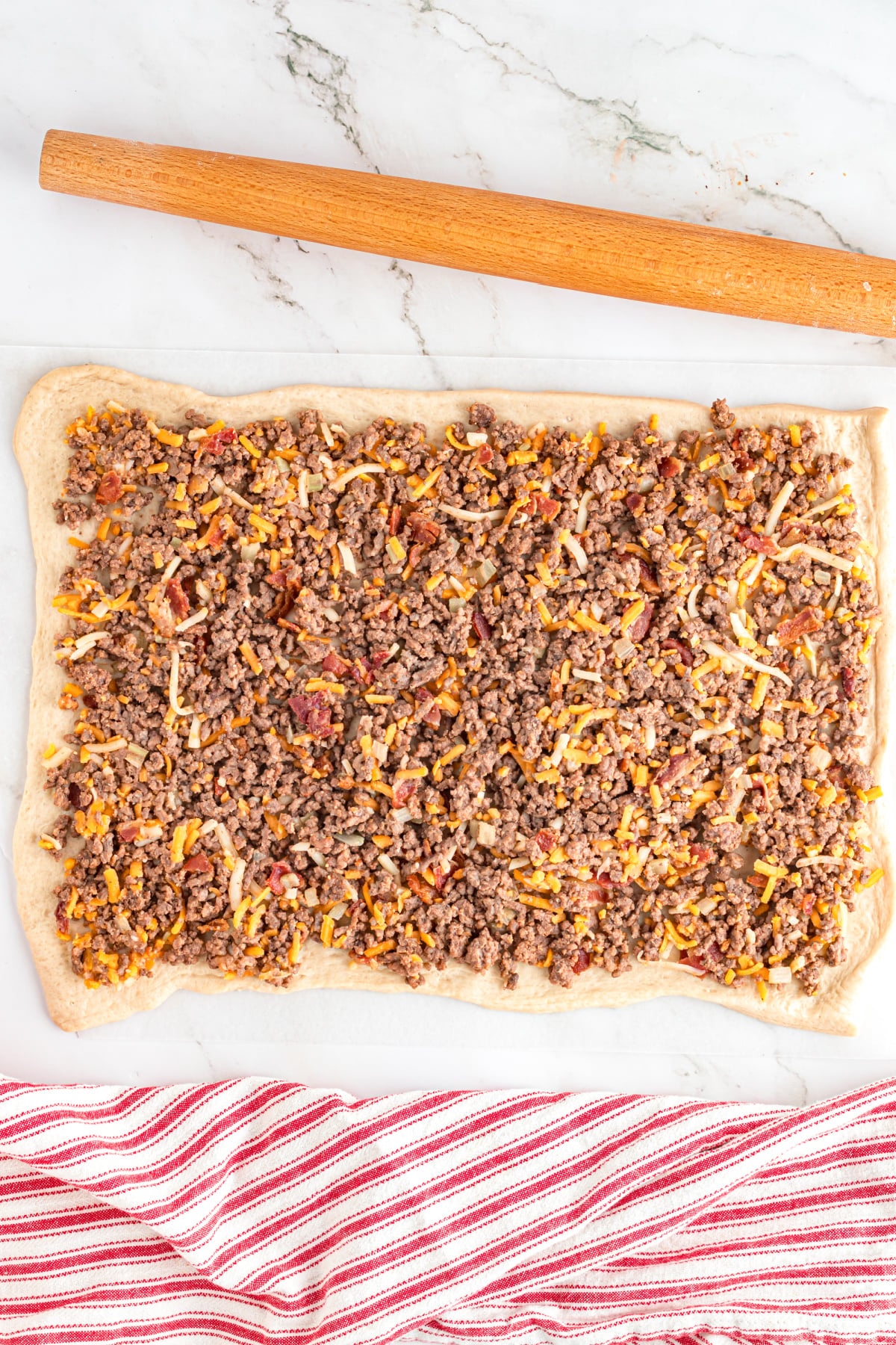 Pizza rolled out into a rectangle and the burger mixture added on top.
