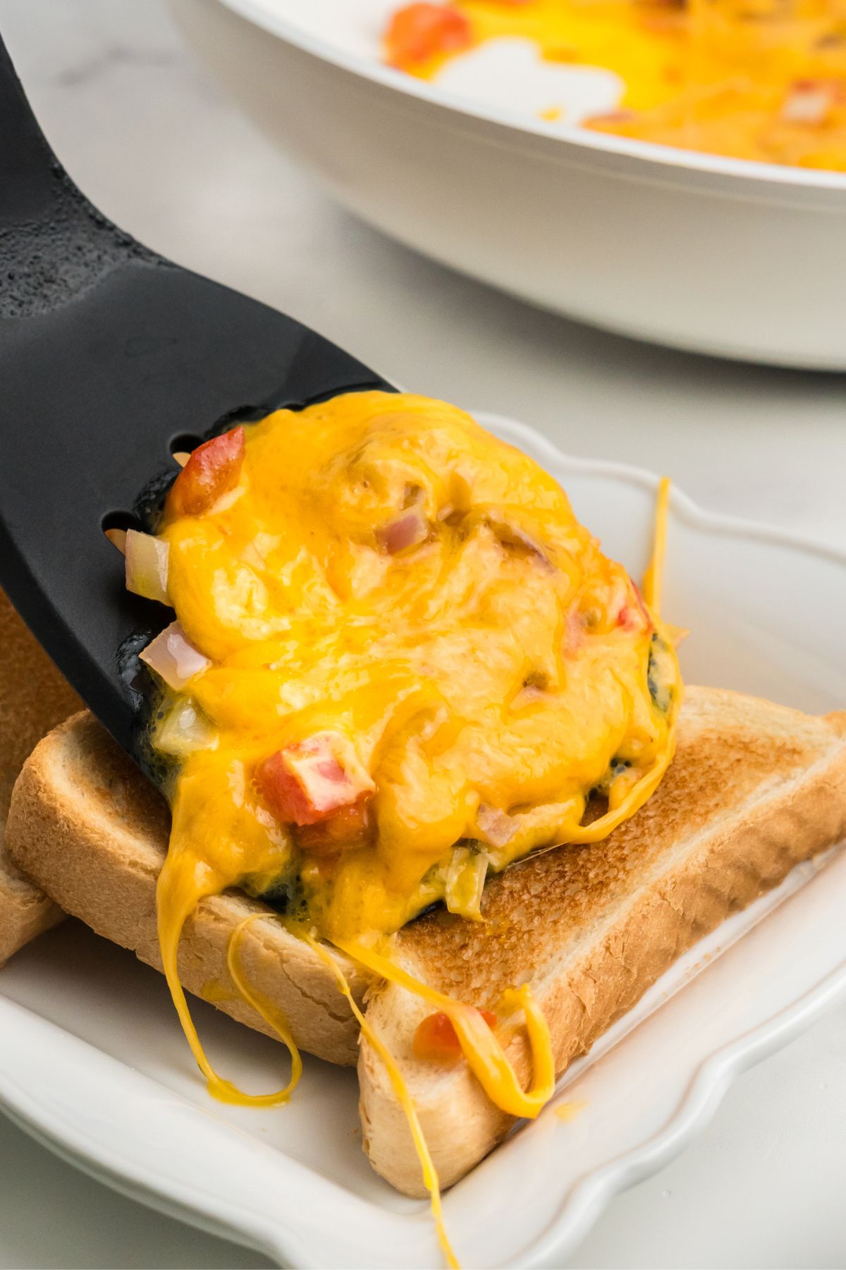 Cheese mixture added onto freshly toasted bread.