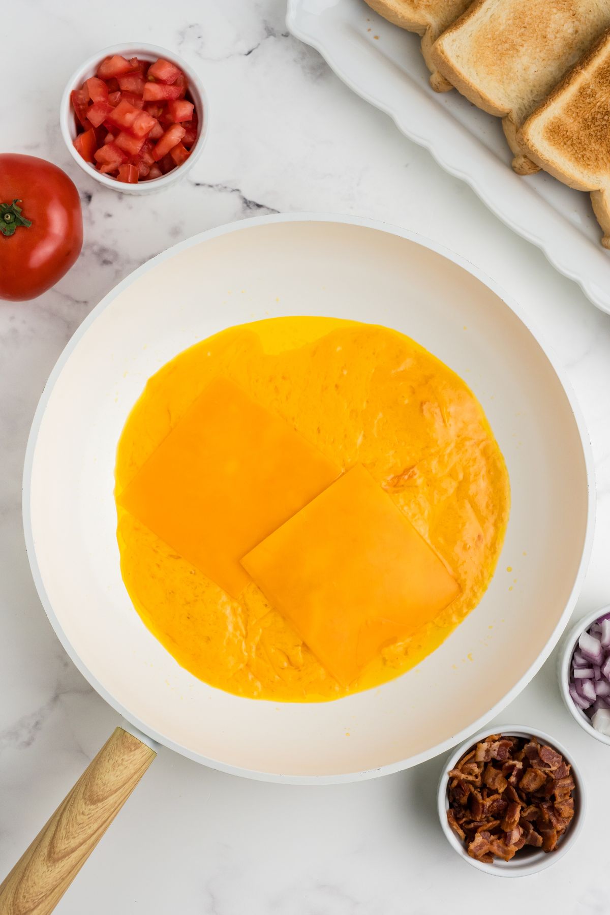 Layer of cheese melting in a skillet.