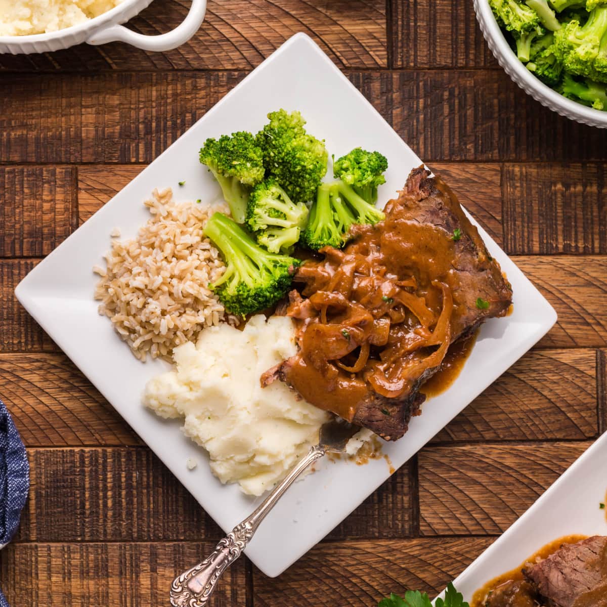 Plate of Slow Cooker Sweet and Sour Beef Roast with mashed potatoes, rice and broccoli with onions 