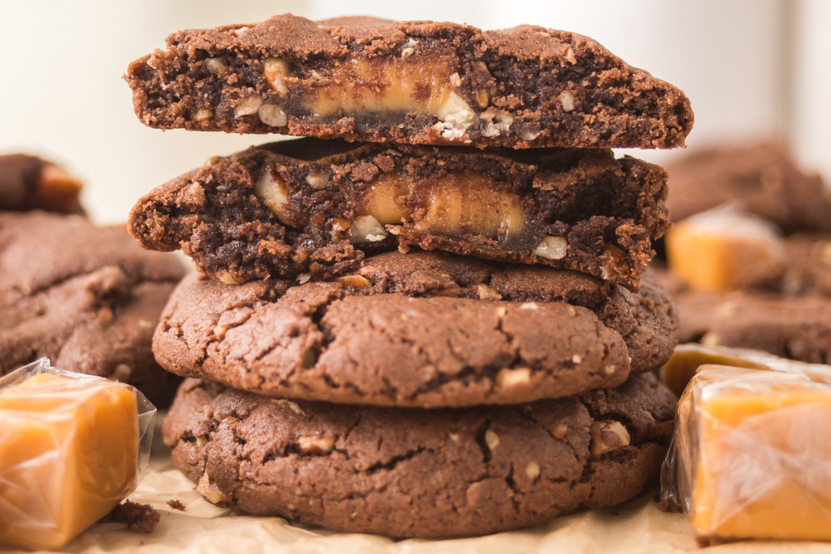 A stack of chocolate cookies with the top one having a bite out of it