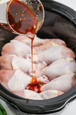 Pouring the sauce over the top of the chicken.