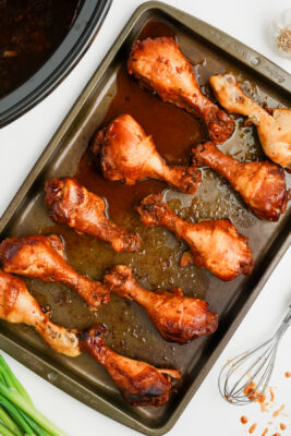 Chicken legs on a baking tray on the counter.