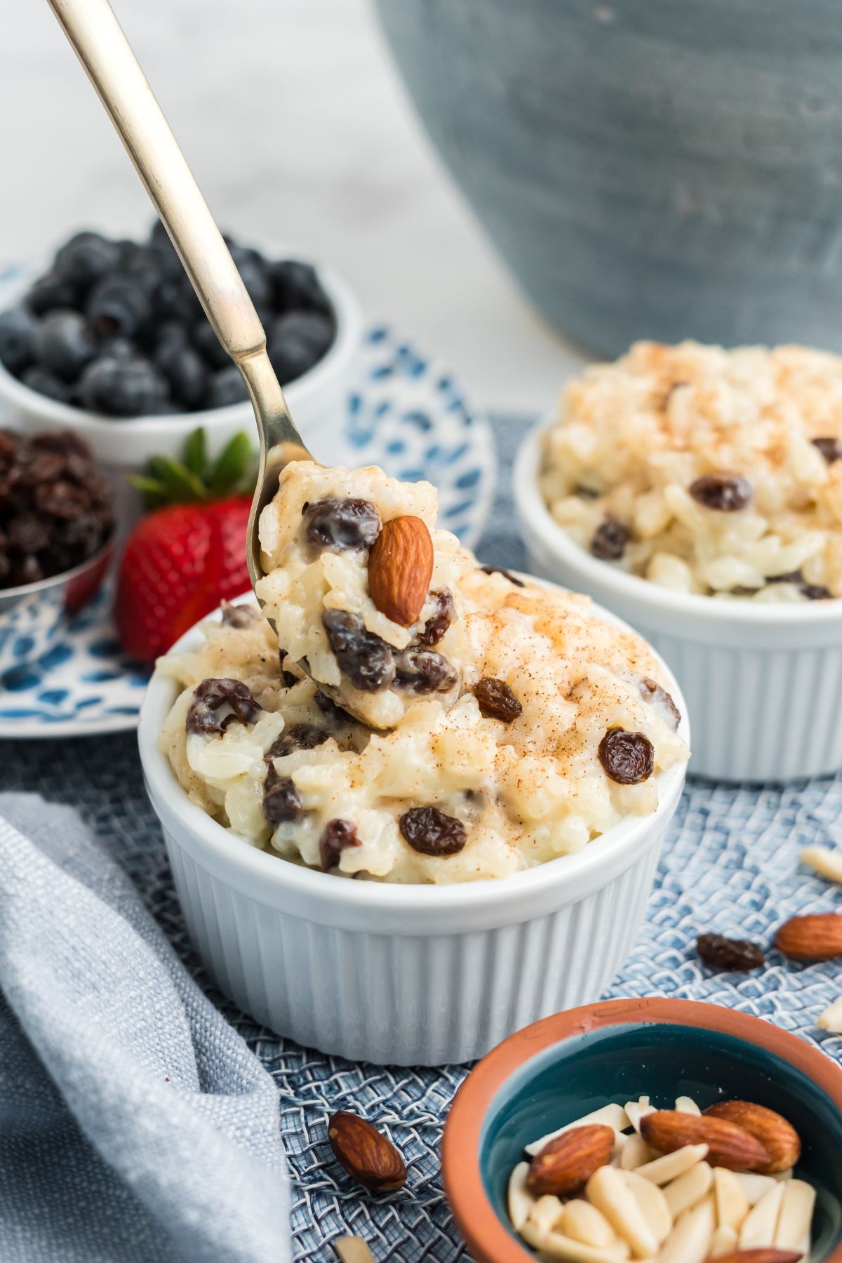 Old-fashioned rice pudding
with raisin and almond inside being scooped with a spoon.