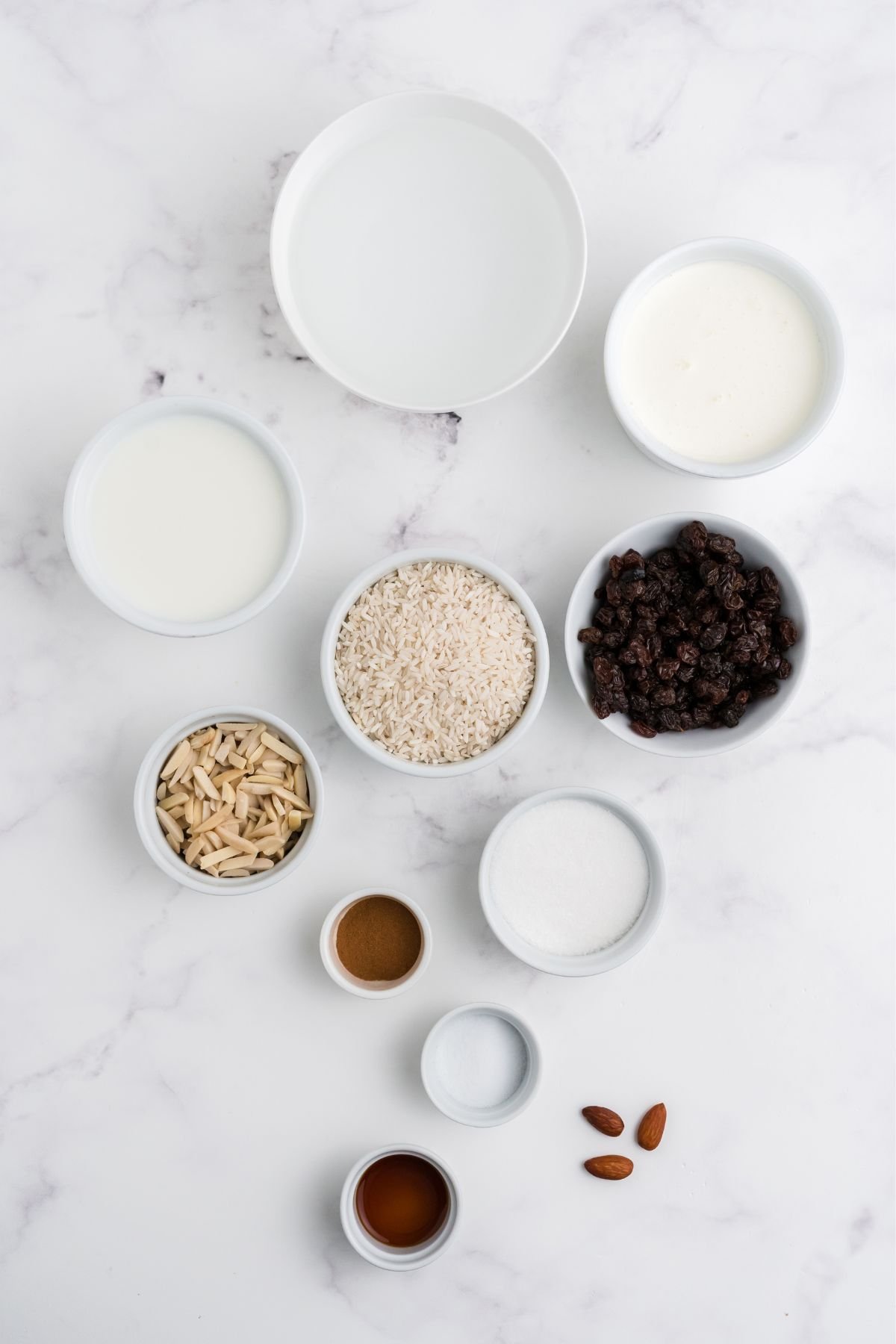 Ingredients for rice pudding in bowls on a table.