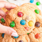 A peanut butter m&m cookie held in the air.