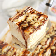 A piece of drumstick cake being held in the air on a spatula.