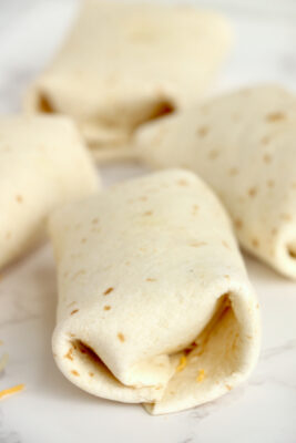 Chicken salad wrap folded over and on counter seam side down.