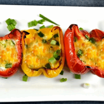 Three peppers with eggs on a plate.