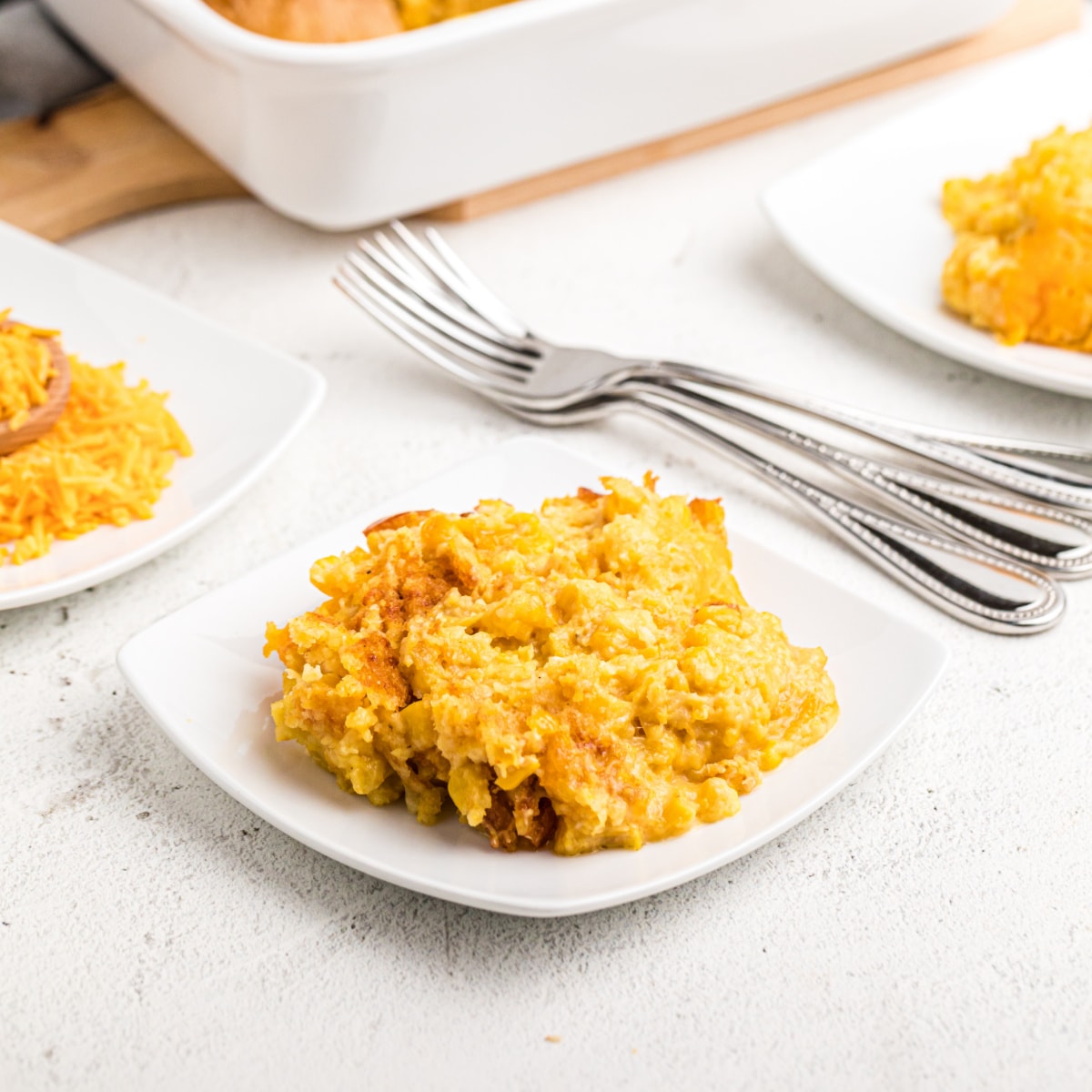Plate of Cheesy Sweet Corn Casserole  with forks in background 