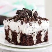 A slice of oreo poke cake on a white plate.