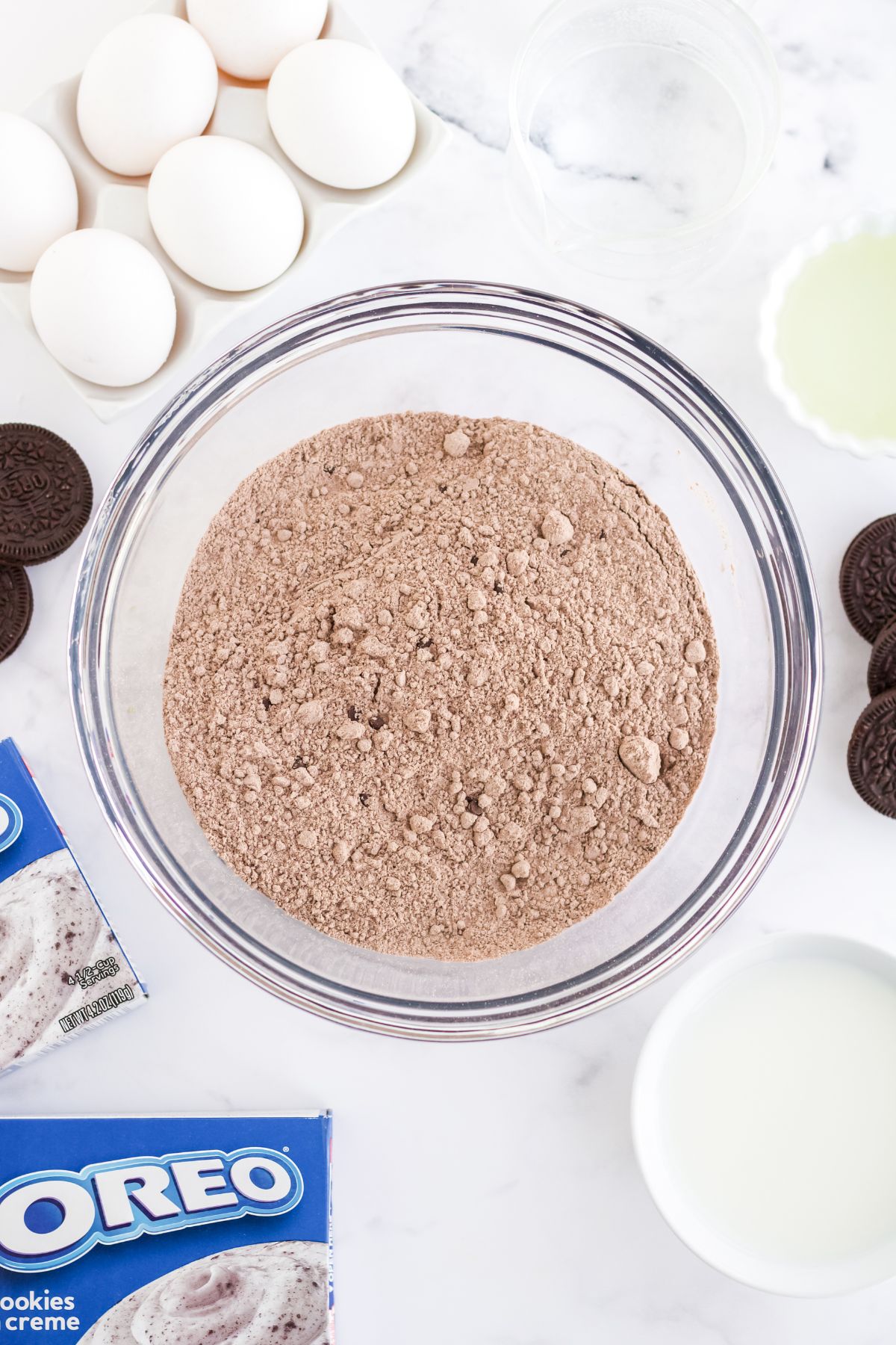 Ingredients for oreo poke cake on a table.