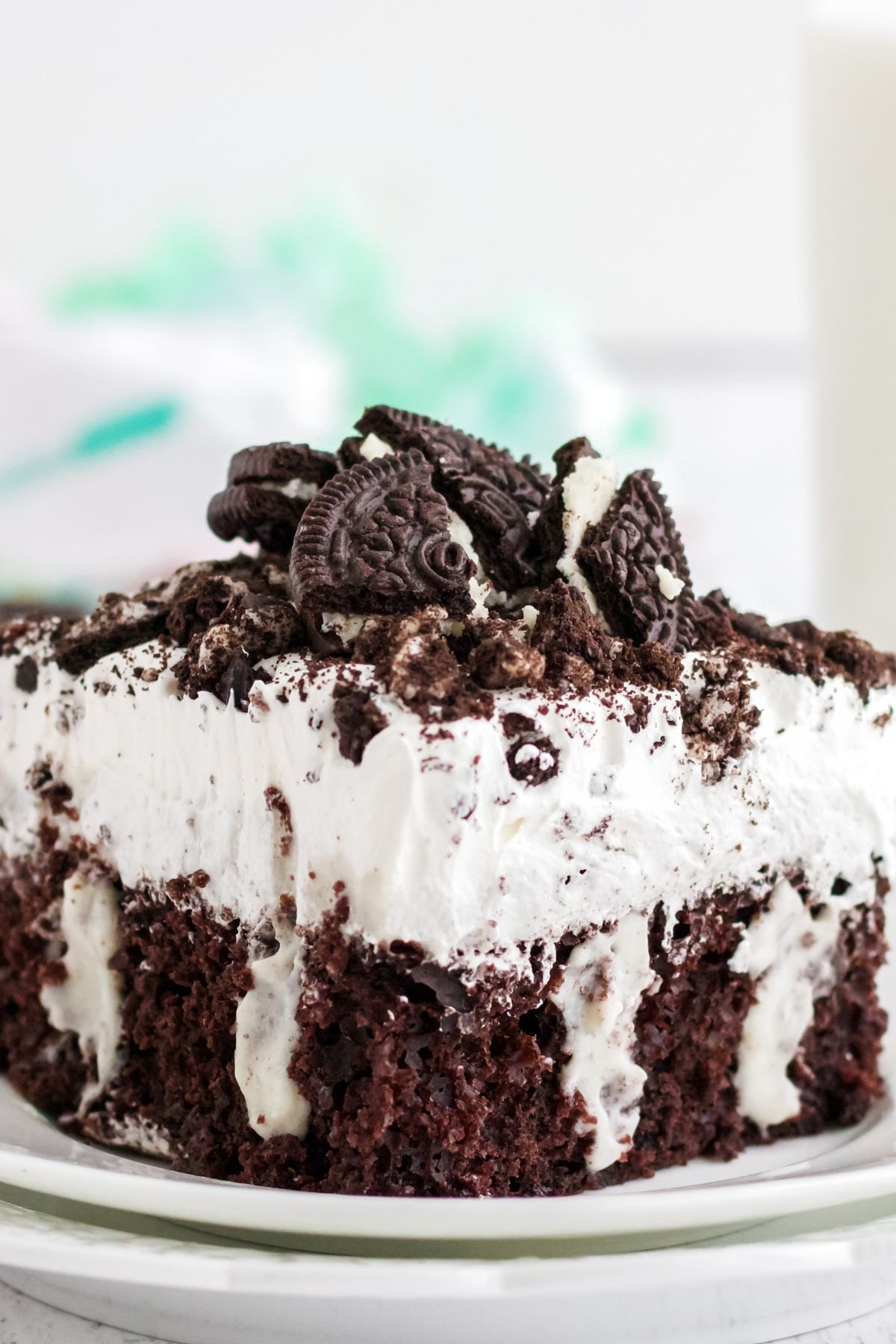 Poke cake on a plate with Oreo crumbed on top.