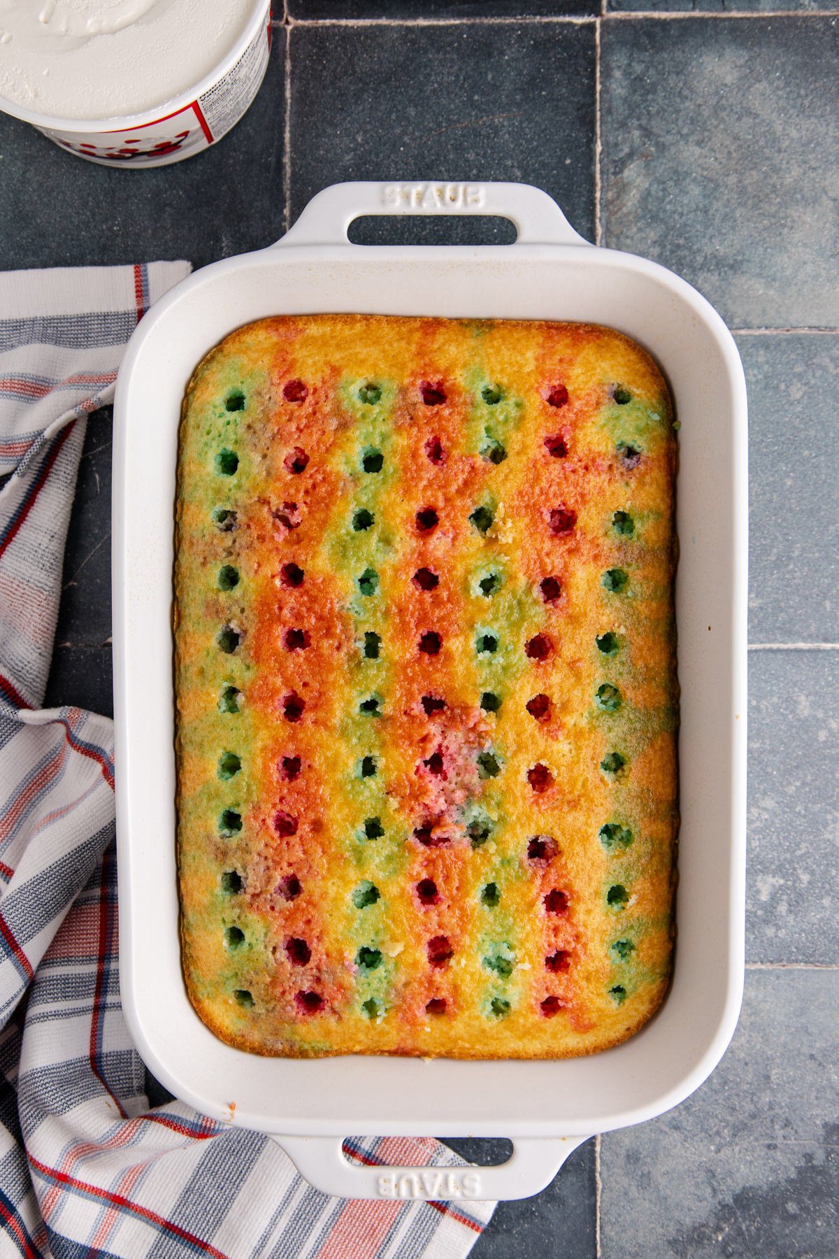 Holes poked into the cake and jello mixture added to the holes.
