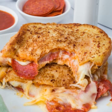 Air Fryer Pizza Grilled Cheese cut in half with top half missing a bite
