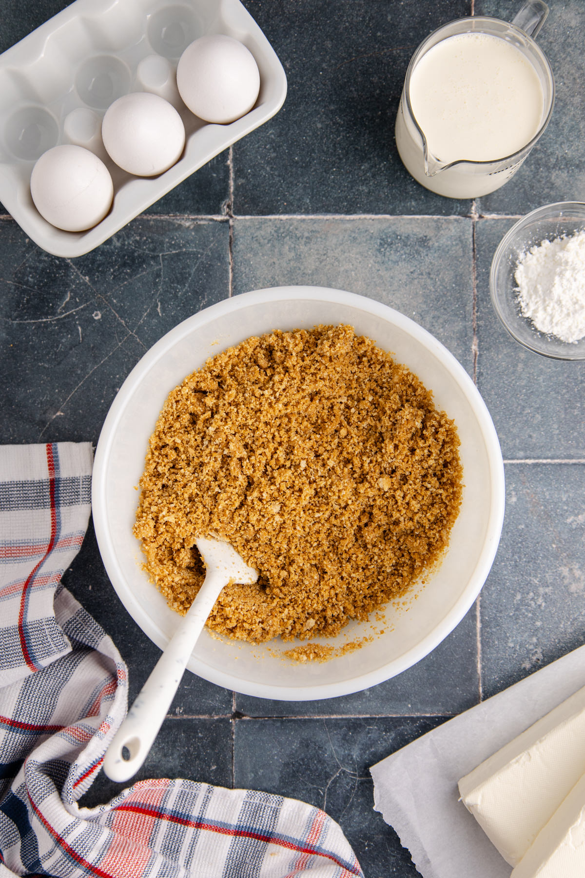 Graham cracker crumbs and melted butter in a mixing bowl.