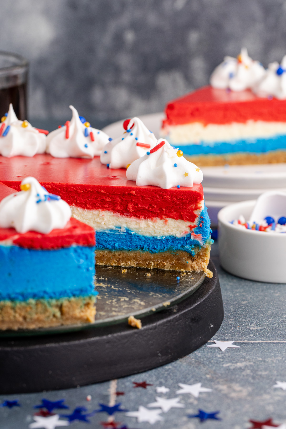 Cheesecake with red, white and blue colors with a slice missing from the cake.
