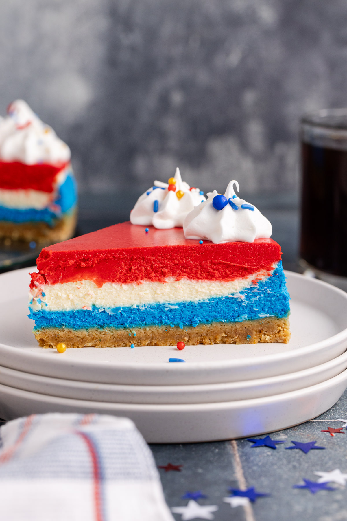 Red, white and blue cheesecake on a stack of plates.