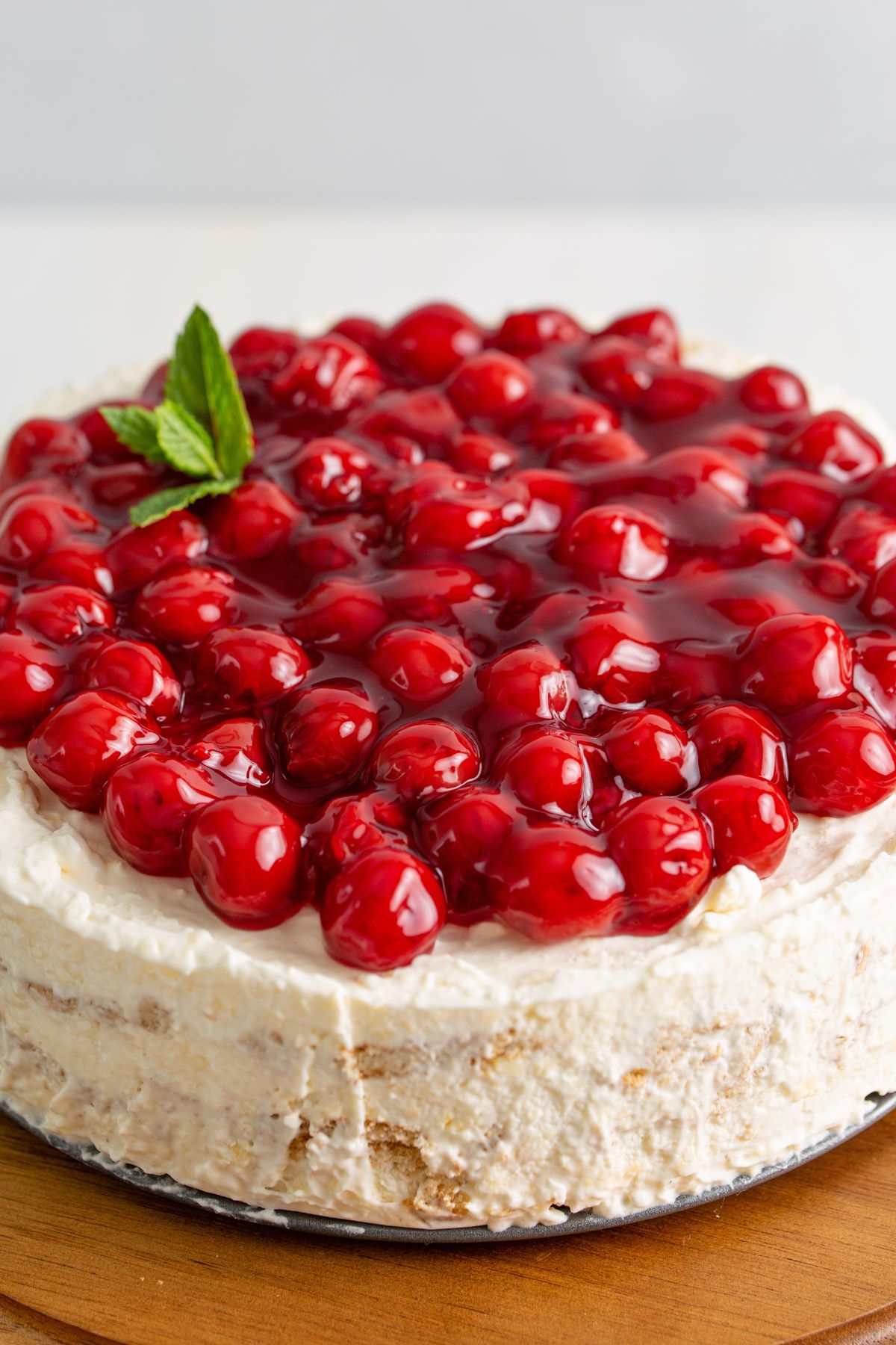 Icebox cake topped with cherries on a table.