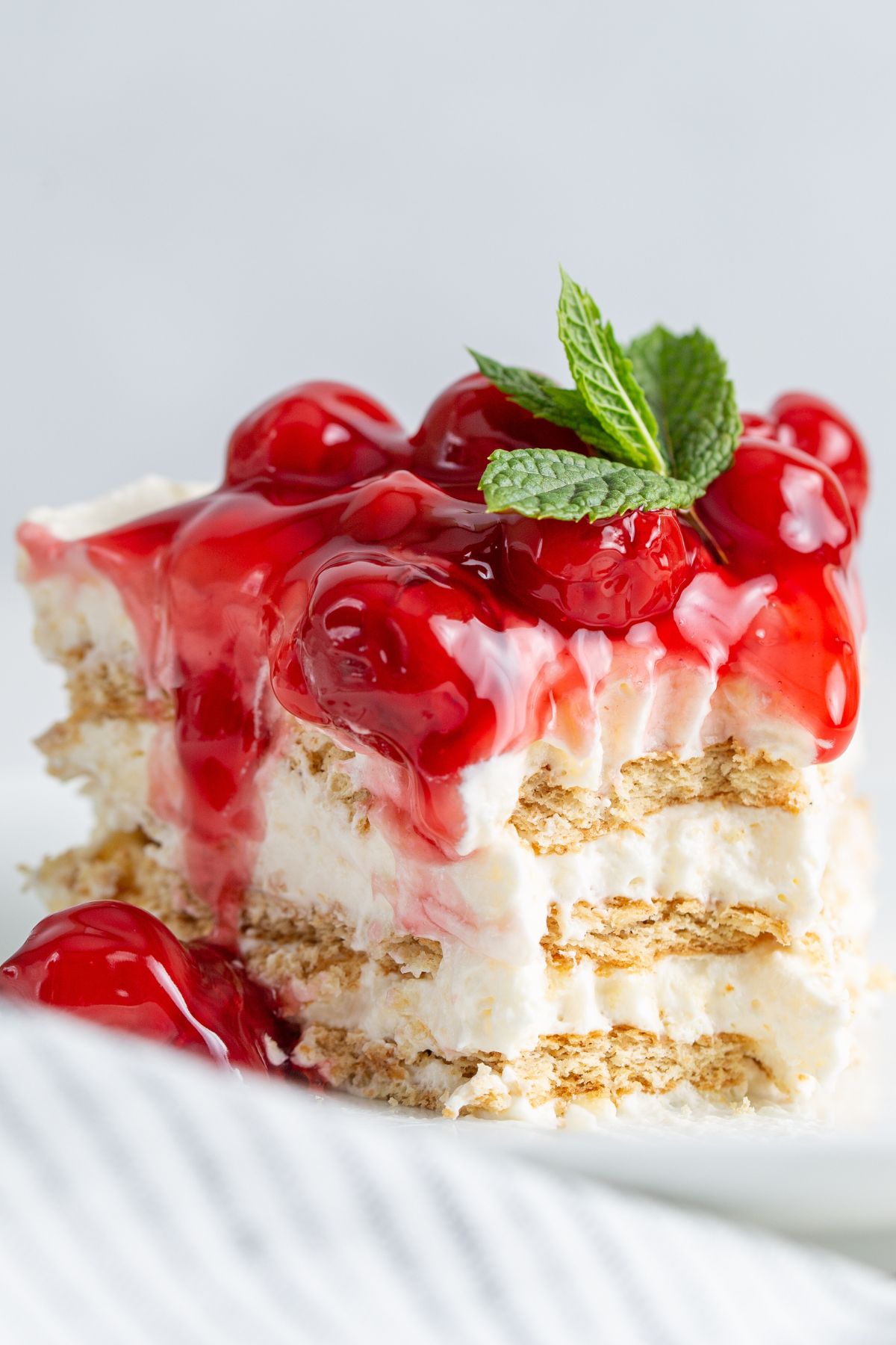 A slice of ice box cake with cherries with a bite taken out.