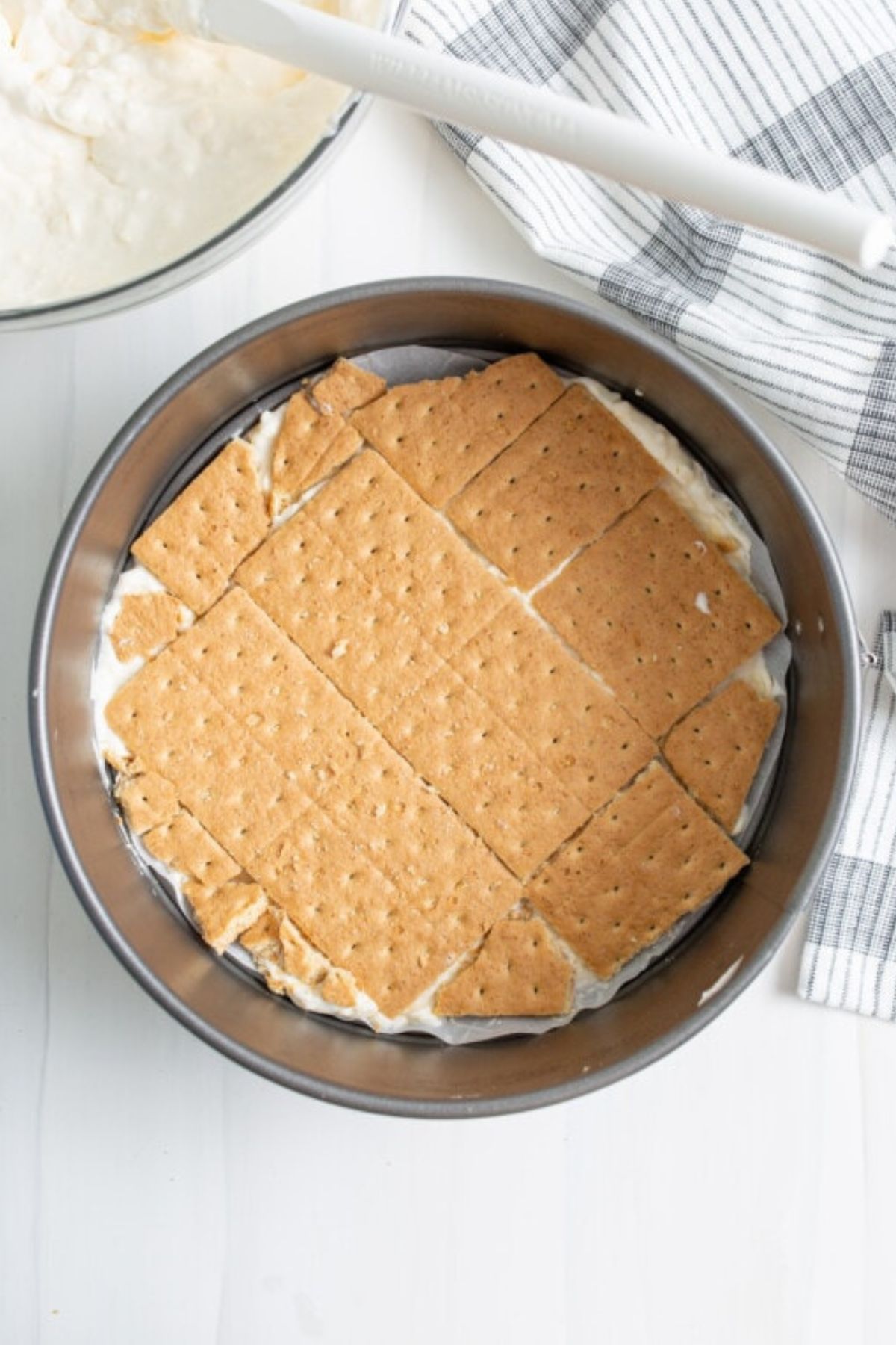Cream cheese mixture into a lined springform pan and full pieces of graham crackers layered on top.