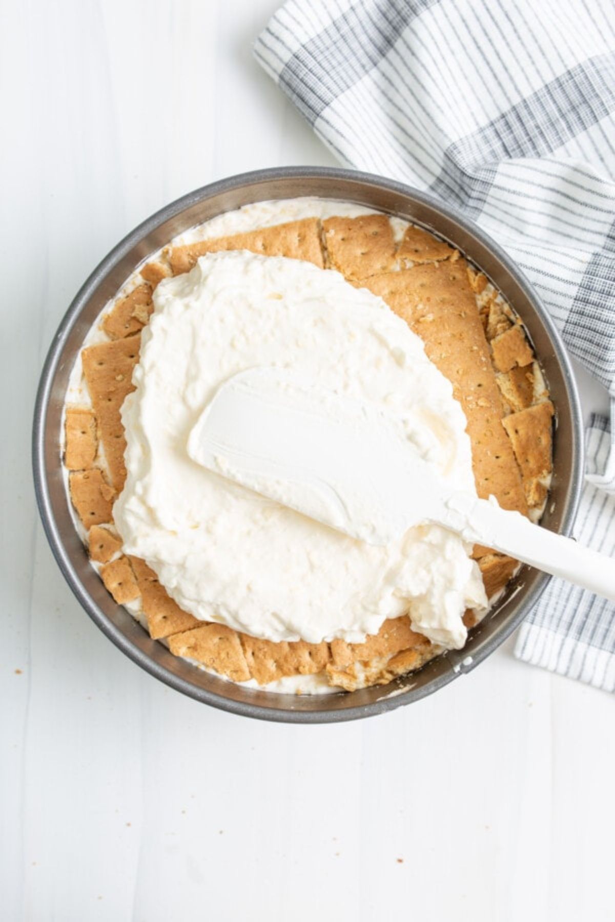 Cream cheese filling spread on top of the graham cracker crust.