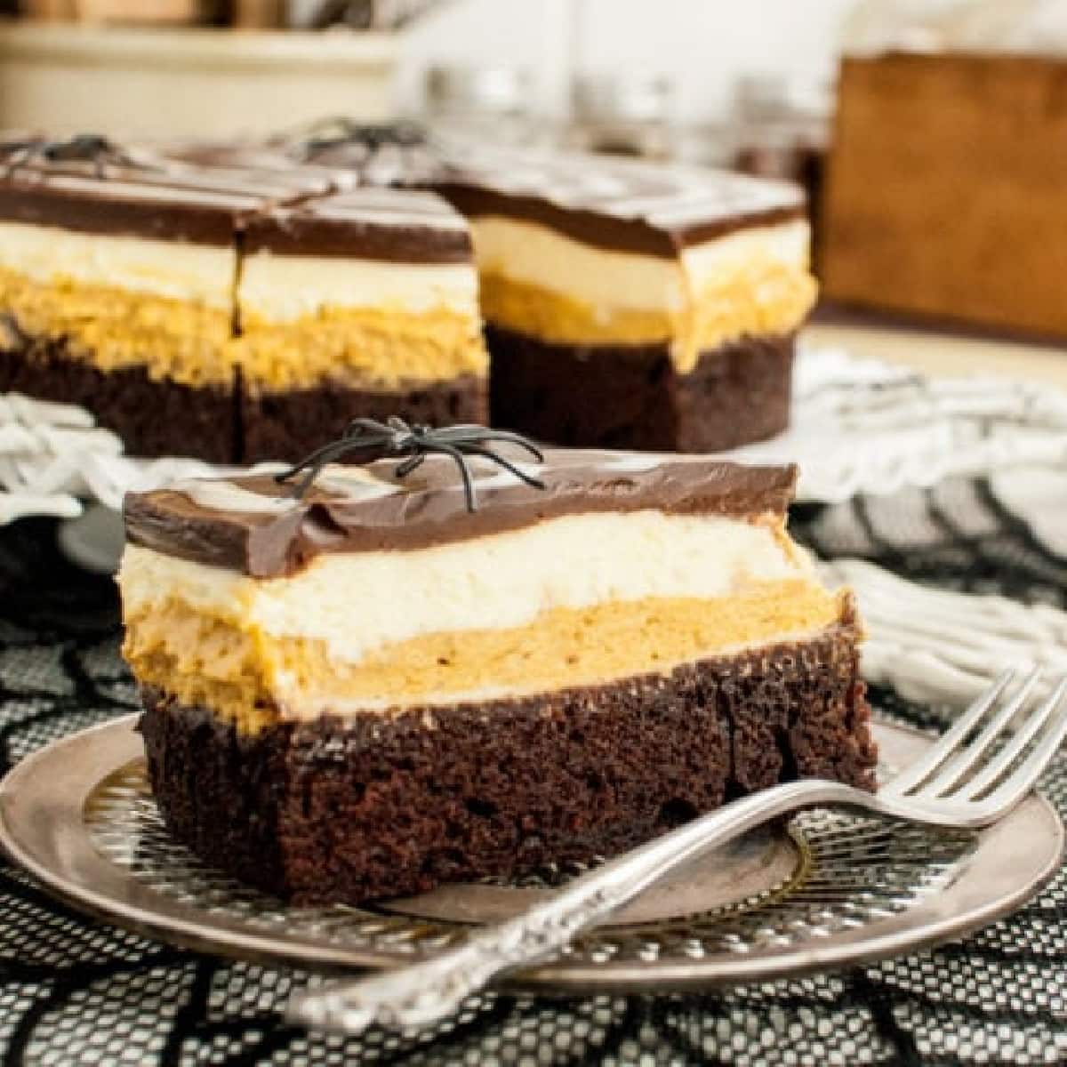 Little squares of Chocolate Pumpkin Mousse Cake on a plate with fork 
