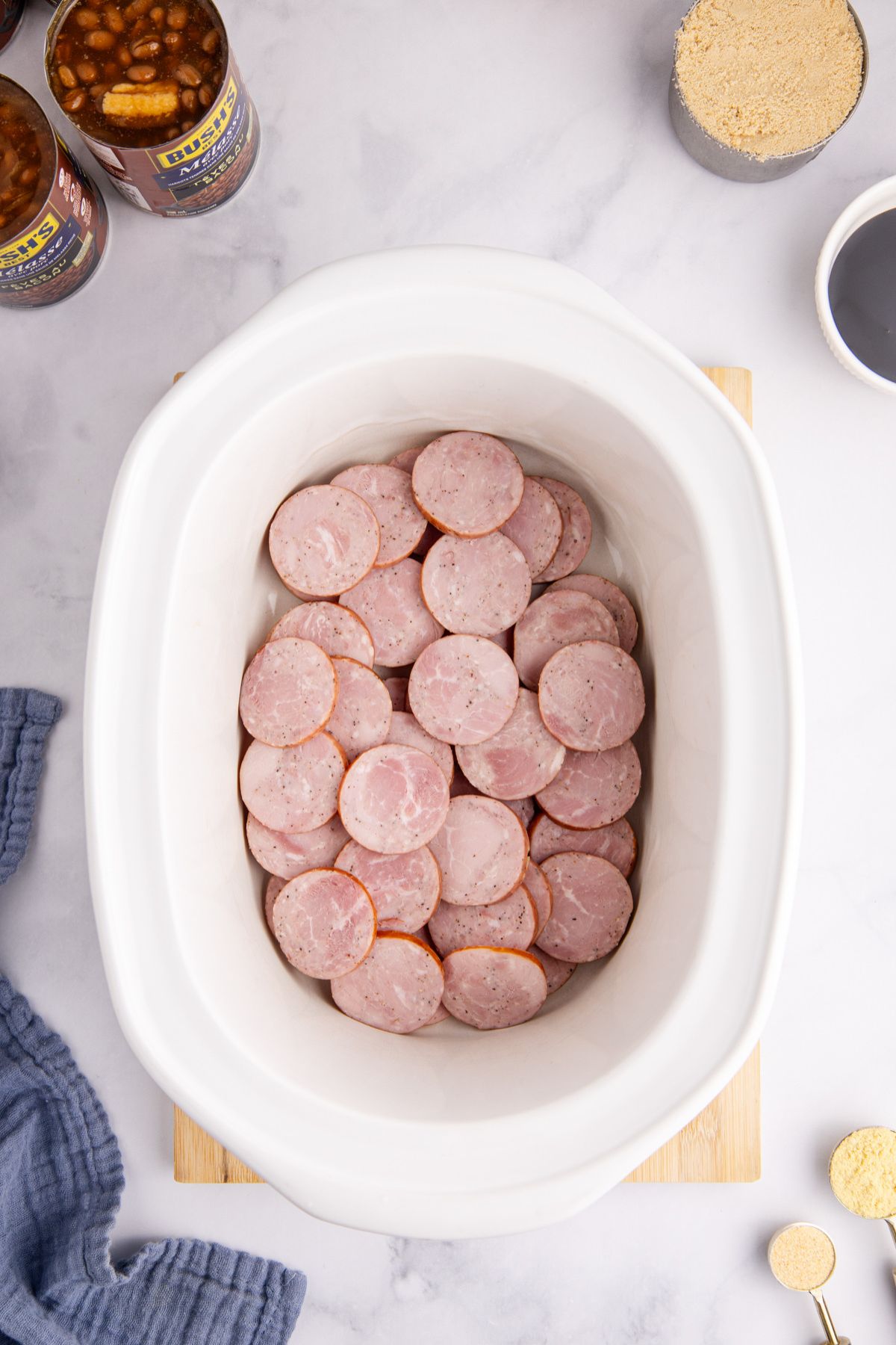 Kielbasa slices in the bottom of a slow cooker.