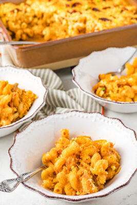 Mac and cheese served in three white bowls.