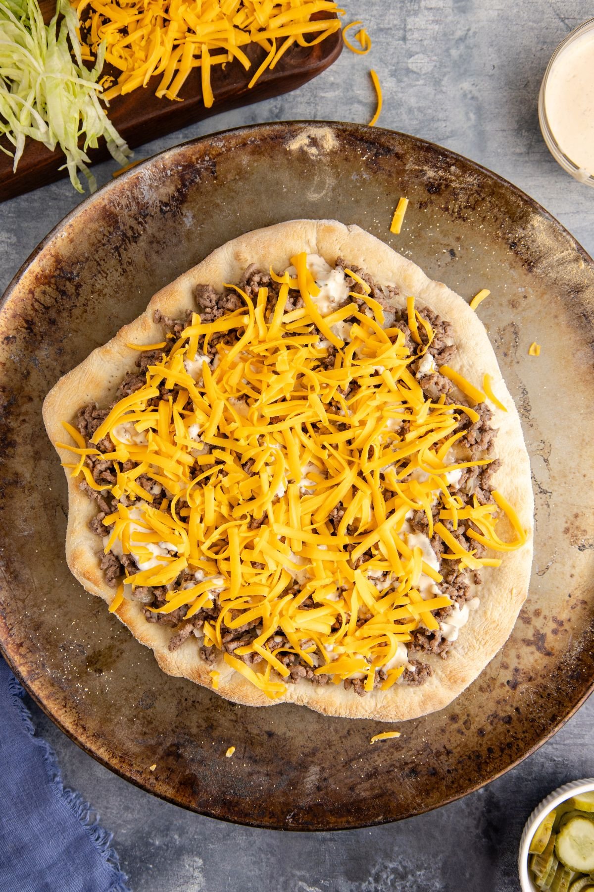 The shredded cheese on top of the beef mixture.