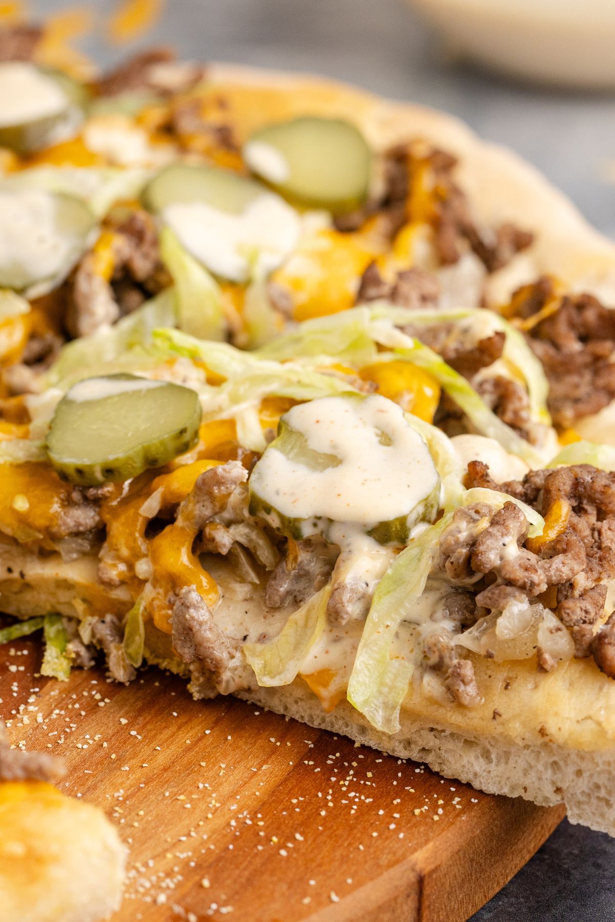 Pizza with big mac sauce over top of lettuce, cheese, beef and pickles.